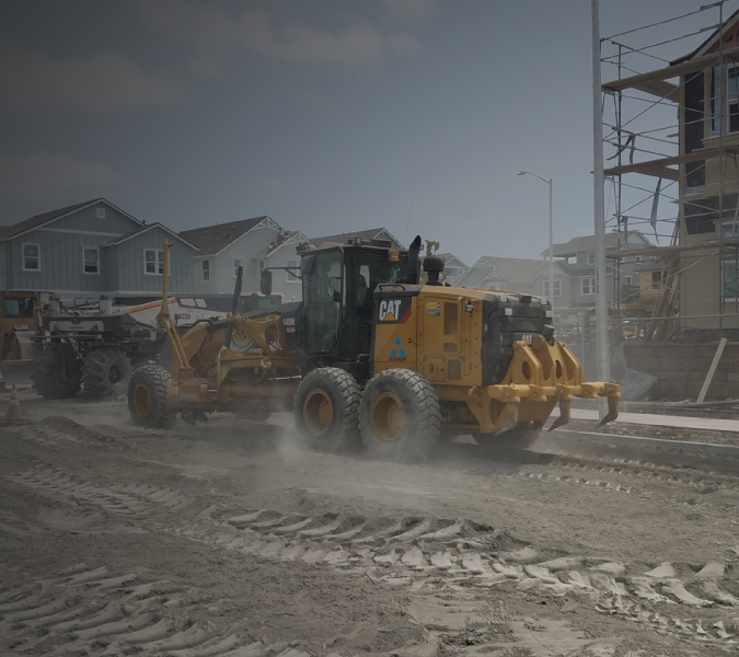 CAT Motor Grader Leveling Roadway During Residential Street Construction